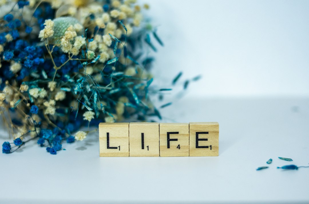a-wooden-block-that-says-life-next-to-a-bouquet-of-flowers-4zmgry348f0
